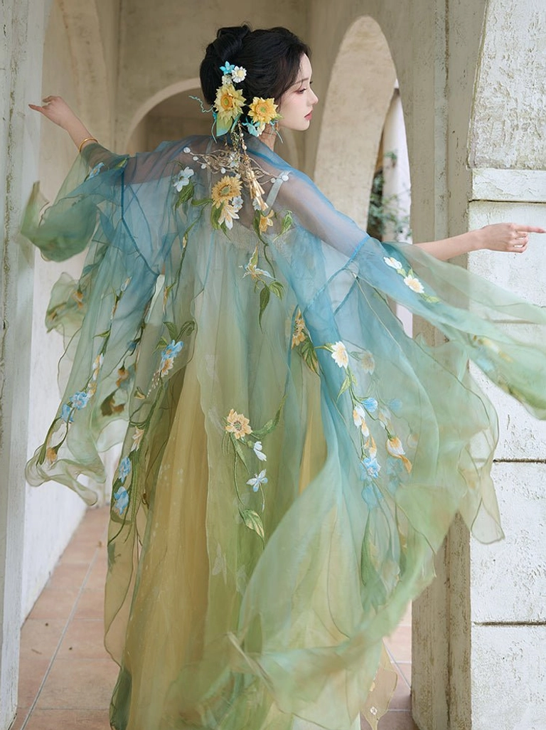 Back three-quarter view of Mint Garden Tang Dynasty Hanfu showing the flowing blue green sheer outer coat, floral back embroidery, and long gradient skirt