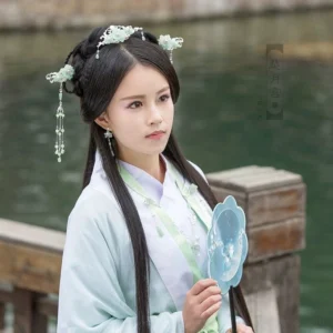 Woman wearing a mint green Hanfu hair accessories set with floral side hairpins and decorative crown beside a lakeside dock while holding a traditional Chinese hand fan