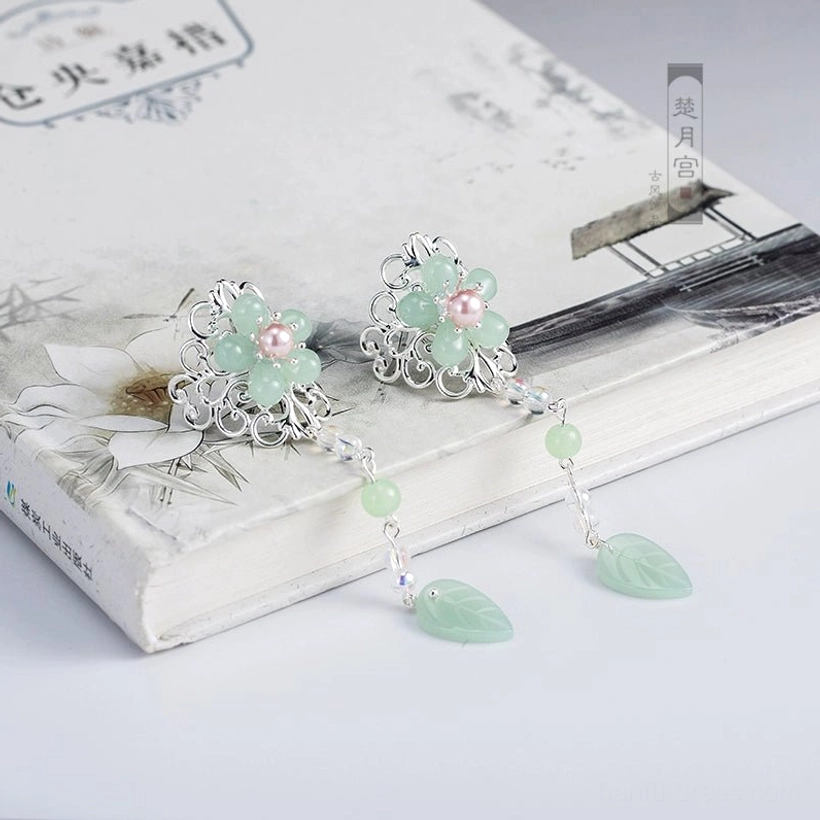 Pair of mint green Hanfu side hairpins with flower-shaped ornaments, pink pearl-style centers, silver-tone filigree, green bead chains, and leaf pendants