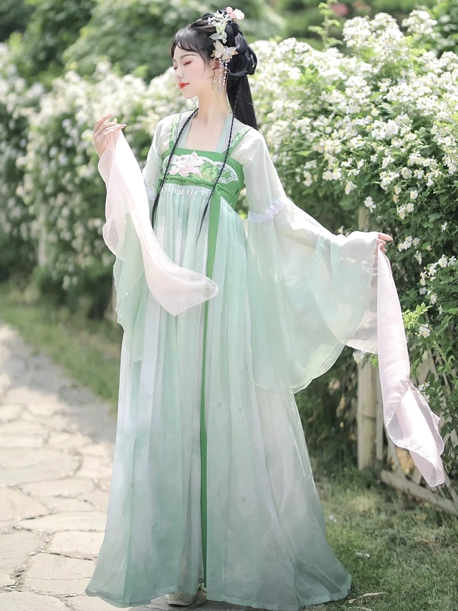 Mint green Qixiong Ruqun Hanfu dress side view showing wide sheer sleeves, long green waist ribbons, pink outer shawl, and floral Chinese hair accessories