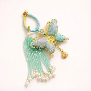 Mint green Song brocade butterfly bag charm and Chinese keychain with gold metal frame, beaded tassel, faux pearl accents, and heart pendant