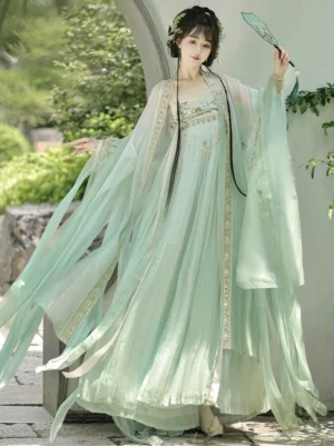 Light mint green Tang Dynasty Hanfu Heziqun complete set displayed in an arched garden doorway with flowing wide sleeves, layered skirt, embroidered bodice, and silk fan