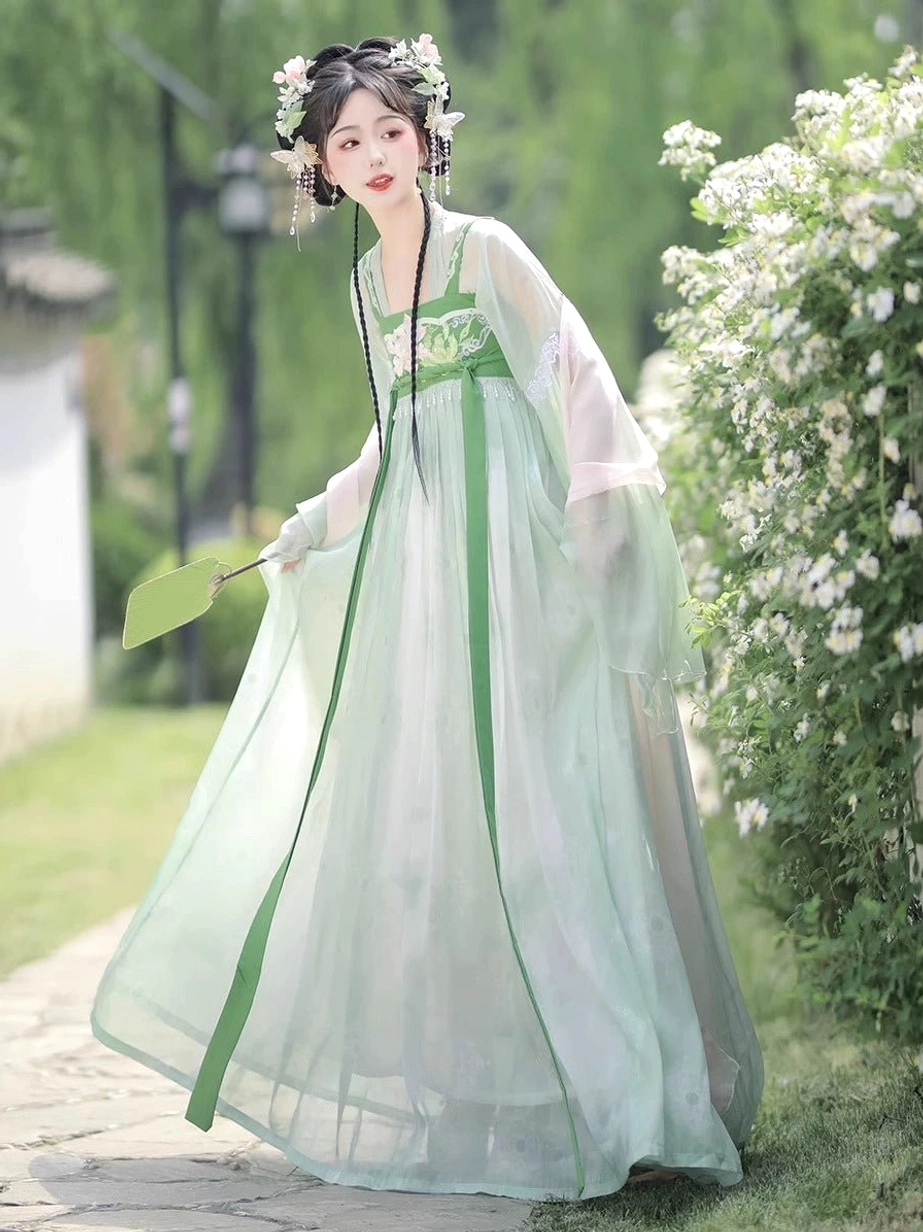 Modern Tang Dynasty Hanfu Qixiong Ruqun in flowing mint green chiffon shown in three-quarter side view with embroidered bust panel and green folding fan