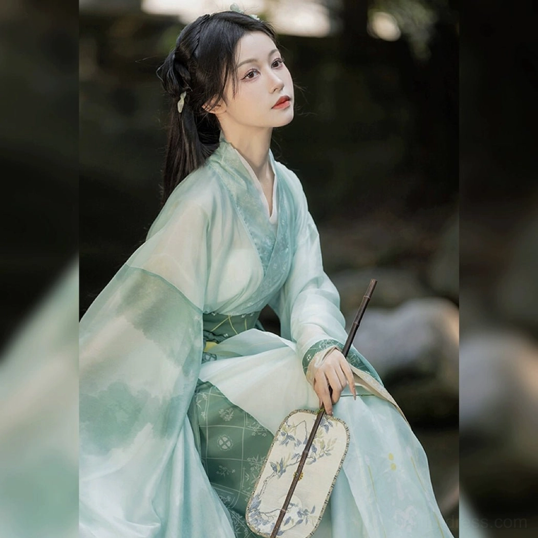 Close-up view of a mint green Wei Jin Dynasty Hanfu top with soft lightweight fabric, detailed cross-collar construction, elegant hairstyle, and painted round silk fan