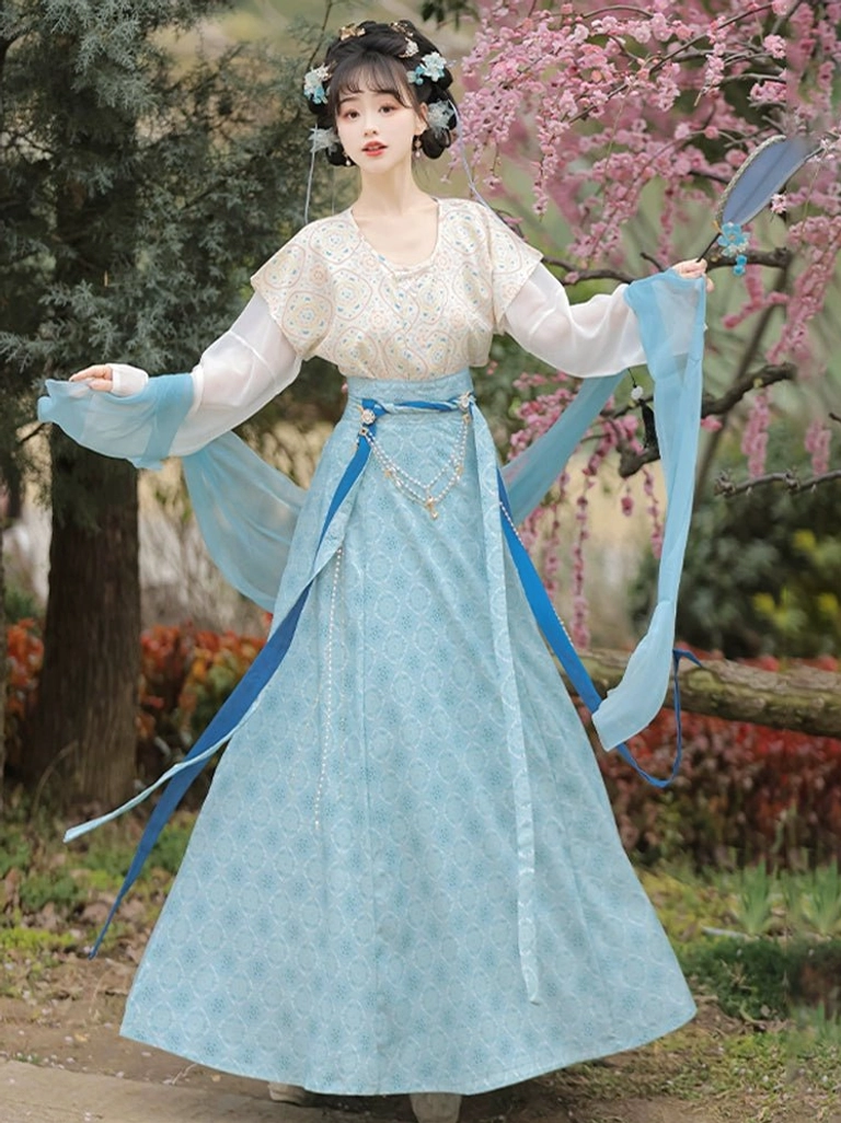 Full length blue Tang style qiyao ruqun Hanfu set displaying flowing sleeve scarves in a spring blossom garden