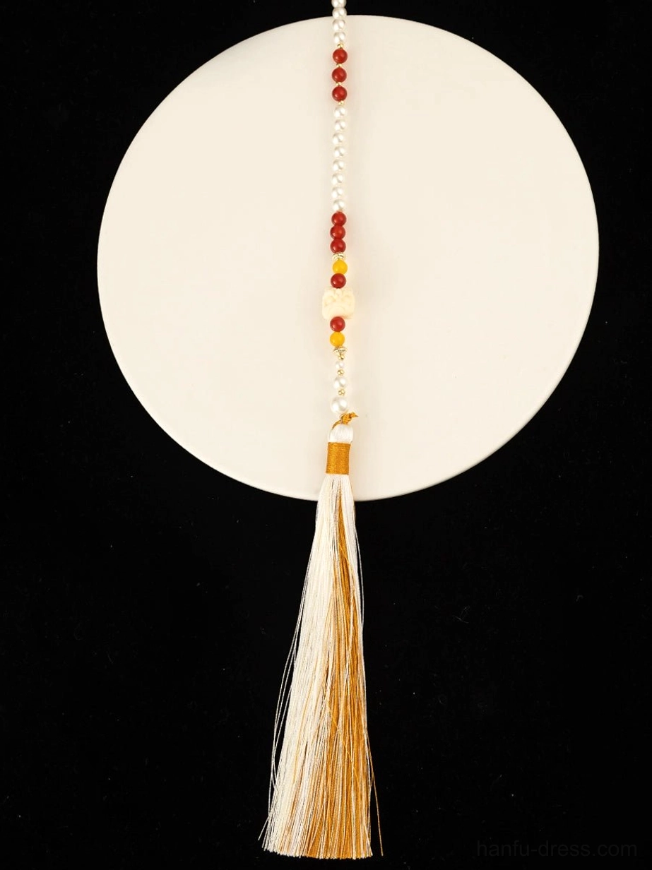 Close up view of a standalone long Chinese necklace tassel with mixed color beads, beige silk fringe, and brown fastening strap