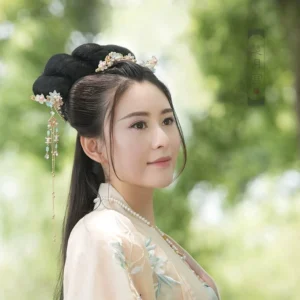 Model wearing colorful spring Chinese hanfu hair accessories with floral crown and matching tassel hairpins in a traditional coiled hairstyle with light yellow hanfu