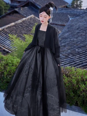 Modern black Tang style Hanfu dress set worn in a traditional Chinese courtyard with a sheer cropped cardigan, square neck dress, ink painting skirt, and waist sash