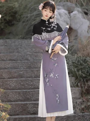 Side view of a modern Chinese cheongsam Hanfu outfit with fitted waist, side tassel pendant, layered white hem, and black embroidered cape beside a garden staircase