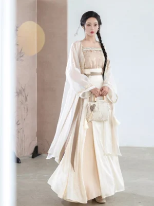 Front view of a modern Chinese style Hanfu outfit with champagne camisole, wide waist belt, flowing pleated skirt, sheer cardigan, and woven vintage handbag