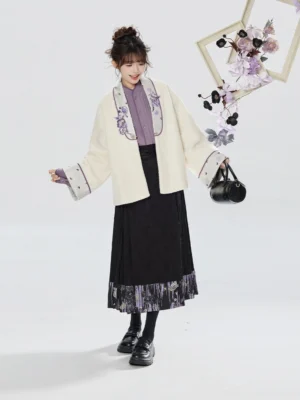 Side view of a modern Chinese hanfu outfit featuring a relaxed cream embroidered jacket, patterned black mamianqun skirt, and contemporary handbag styling