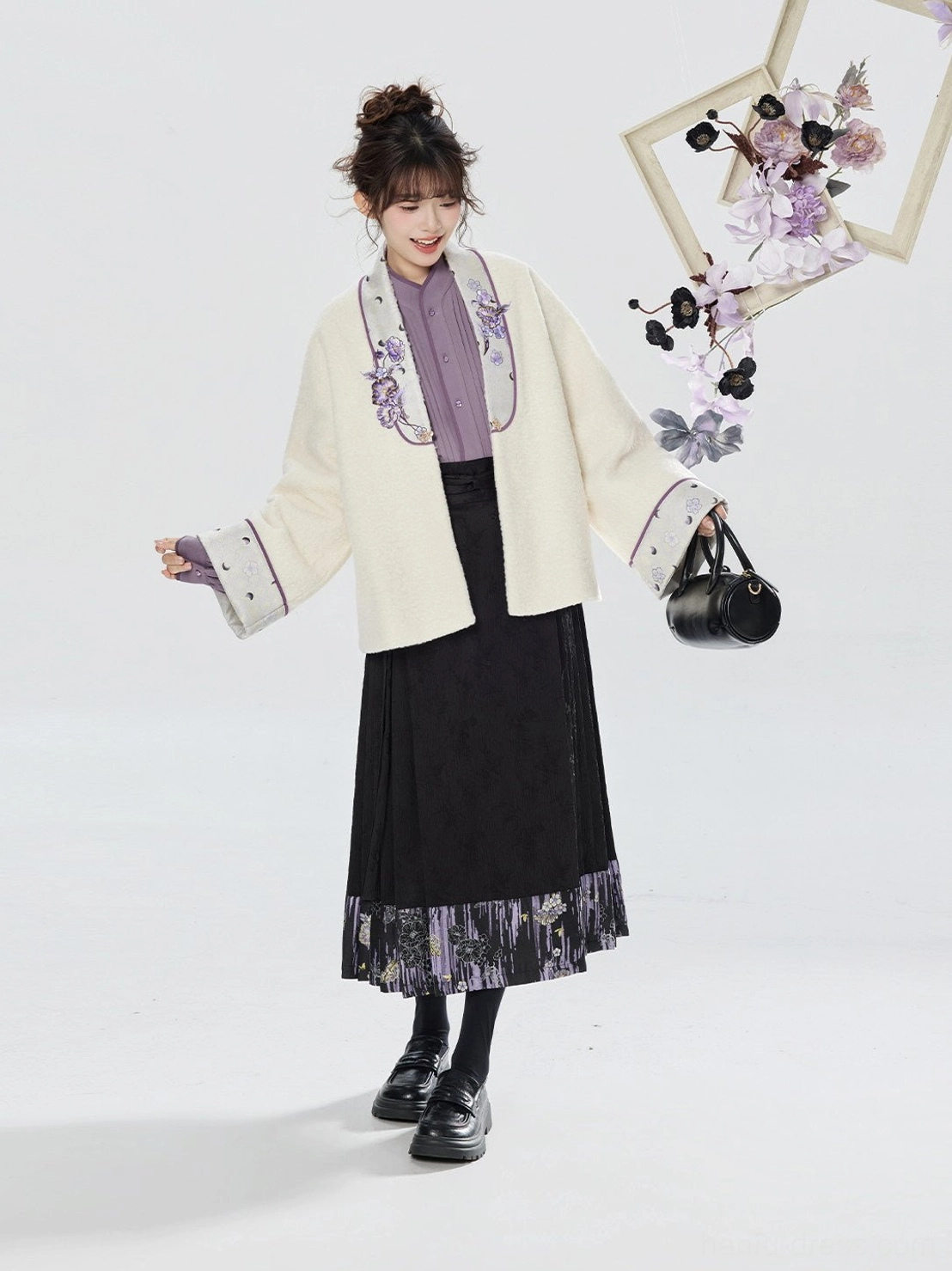 Side view of a modern Chinese hanfu outfit featuring a relaxed cream embroidered jacket, patterned black mamianqun skirt, and contemporary handbag styling