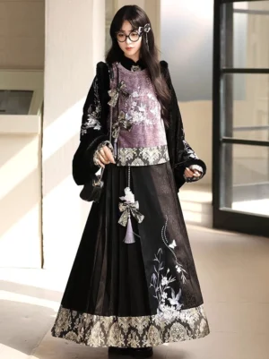 Front view of a modern Chinese hanfu outfit featuring an embroidered vest, long-sleeve top, black mamianqun skirt, and decorative waistband details