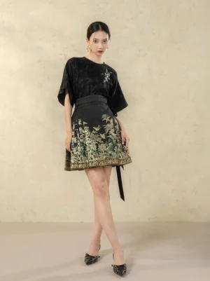 Three-quarter view of a modern Chinese Hanfu mini horse-face skirt outfit showing the gold hem trim, floral print, and long side waist sash