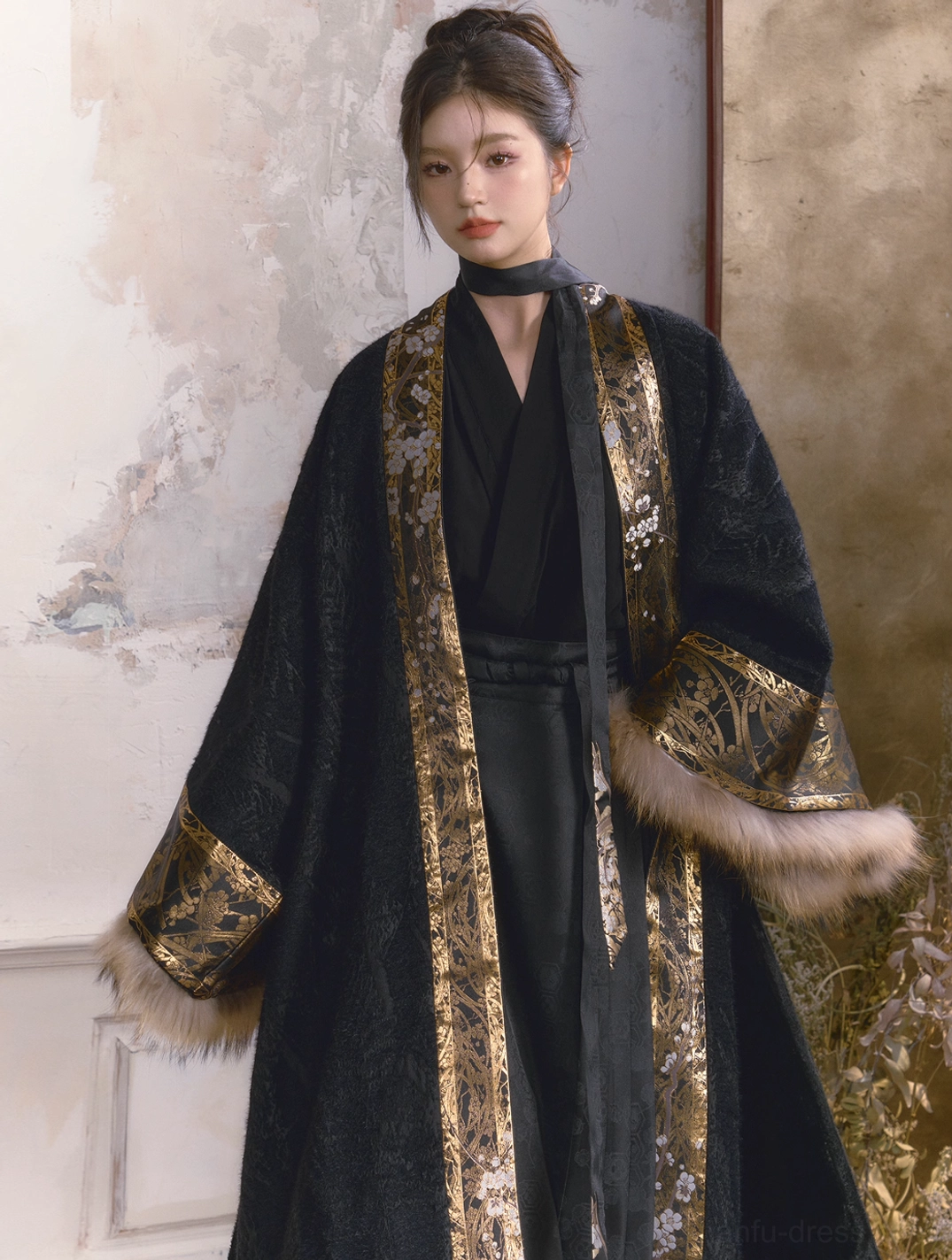 Front view of a modern Chinese Hanfu outer coat in textured black fabric with gold patterned placket trim and fluffy removable fur sleeve details