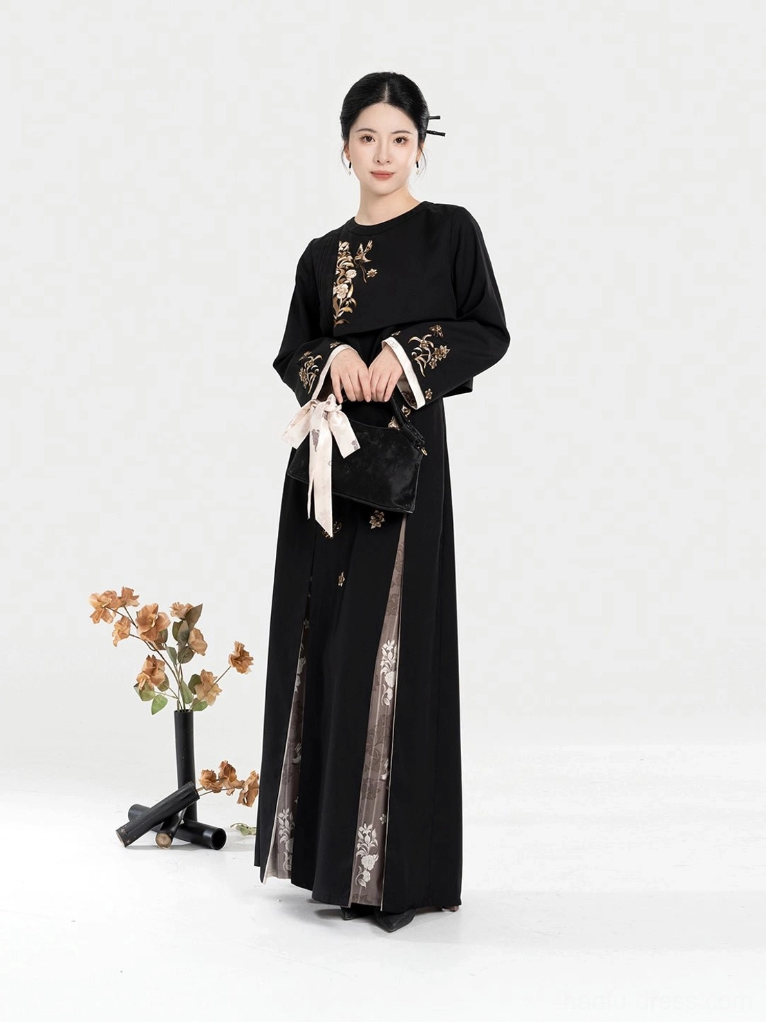 Front view of a modern Chinese-style Hanfu outfit with golden floral embroidery, stand-collar cropped jacket, high-waisted skirt, and contrasting side slit panel