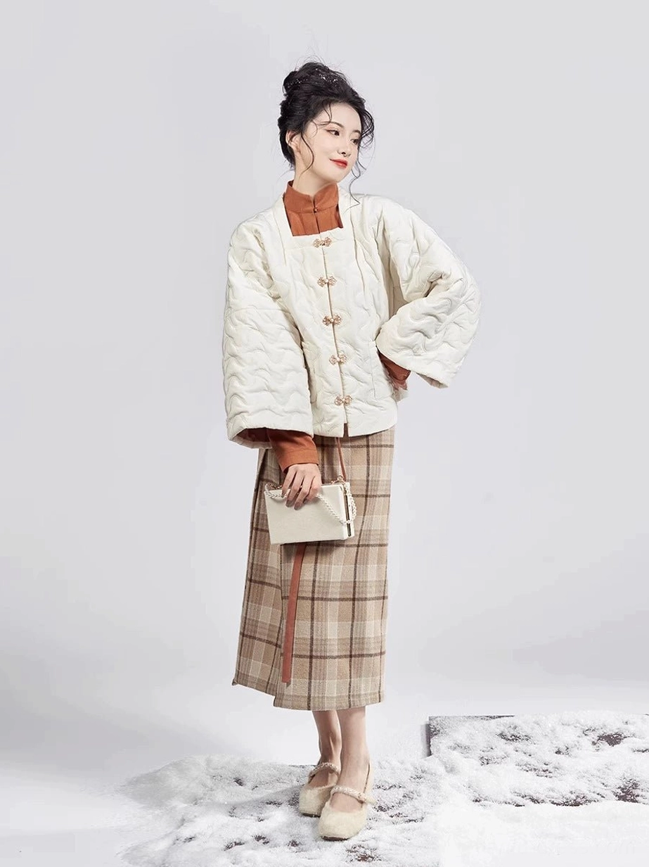 Side profile of a complete modern Chinese Hanfu outfit with cream padded jacket neat frog buttons caramel top and plaid wrap skirt