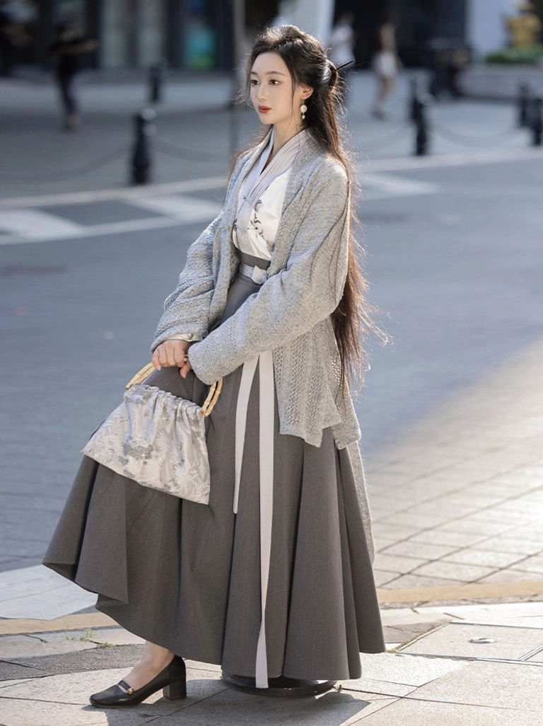 Side view of modern Chinese style Hanfu outfit with floral cross collar top pleated wrap skirt grey cardigan and matching handbag
