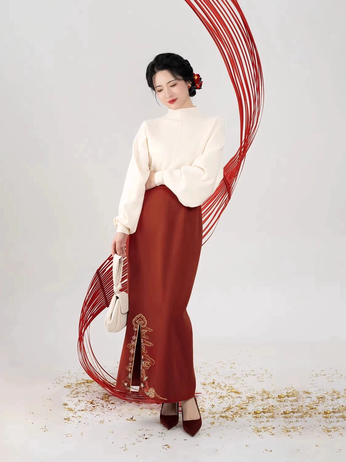 Modern Chinese Hanfu styling with loose off-white turtleneck top and long burgundy skirt decorated with golden embroidery at the front slit