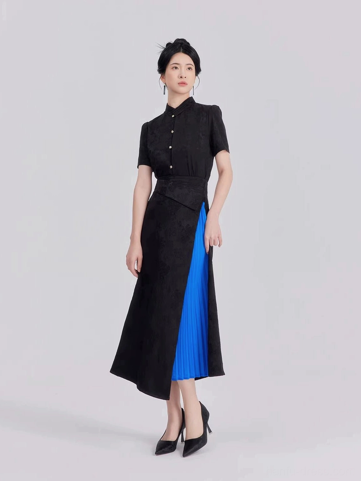 Front view of modern Chinese style women's Hanfu set with fitted cropped stand collar shirt pearl-style buttons and blue pleated skirt panel