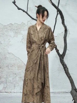 Side profile of a modern Chinese style Hanfu wrap dress with long sleeves, subtle floral jacquard texture, adjustable waist sash, and flowing full-length skirt