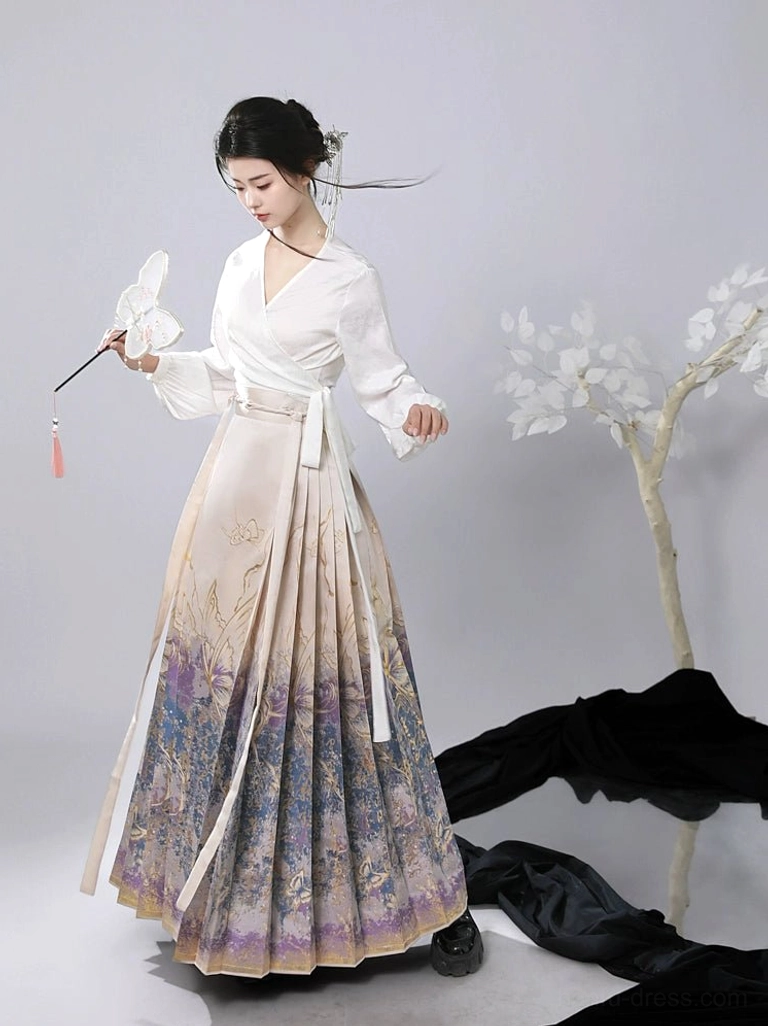 Three quarter side view of a flowing modern Chinese mamianqun horse face skirt with vintage gradient print, gold artwork, pleats, and long waist sash