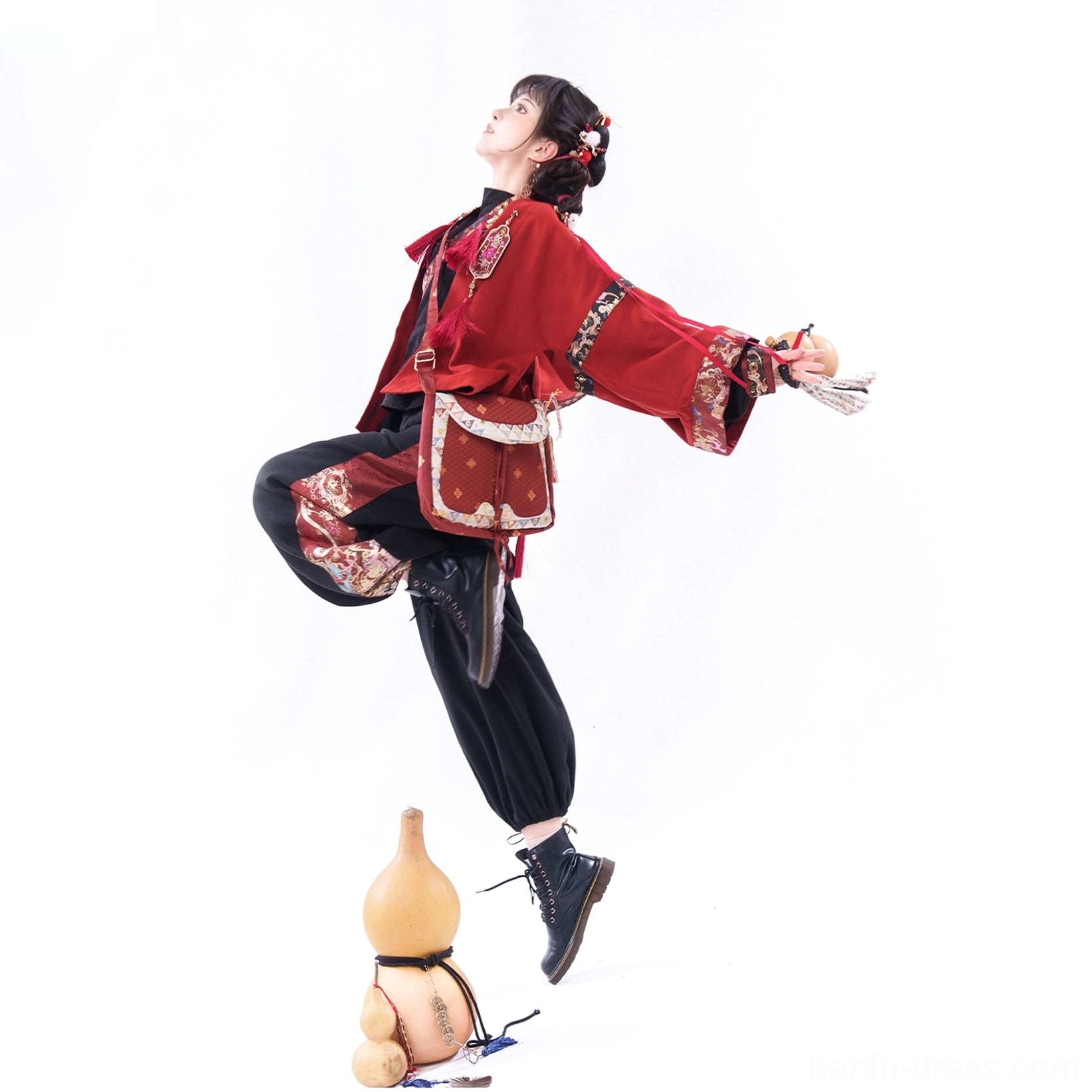 Modern Chinese New Year Hanfu outfit with red embroidered waist bag, black wide-leg pants, patterned side trims, and boots