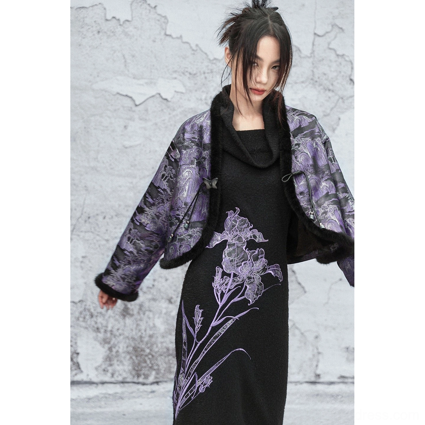 Medium front view of a woman wearing a dark purple and black modern Chinese style cropped jacket with relaxed open styling and plush trim