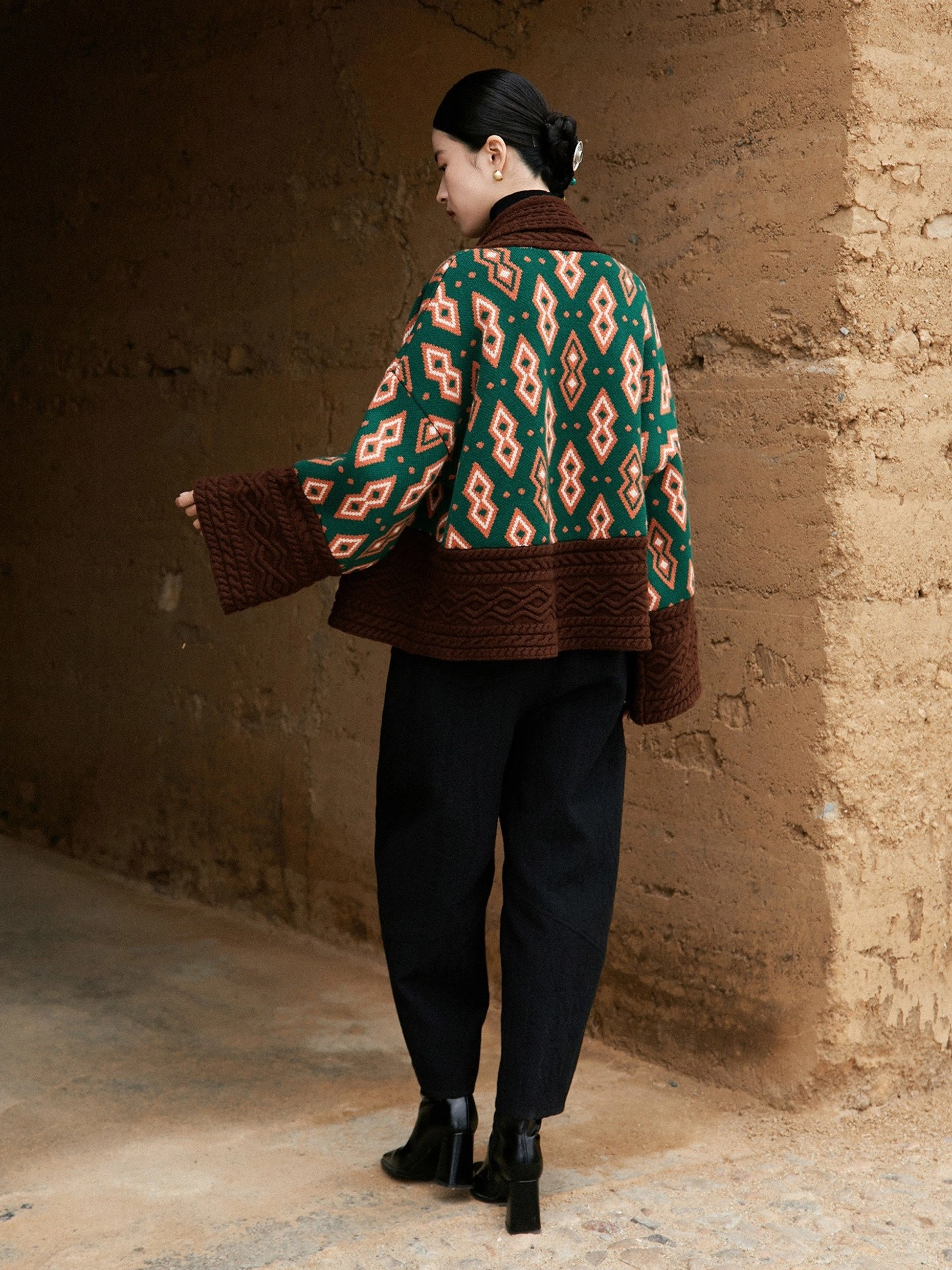 Back view of modern Chinese style Hanfu knit cardigan jacket showing full geometric jacquard pattern wide flared sleeves and cropped length