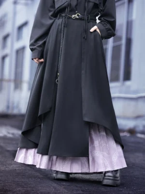 Close-up view of modern Chinese style wide-leg culottes showing asymmetric black layered hem, light purple pleated underlayer, waist belt buckle, tassel chain, and black platform boots