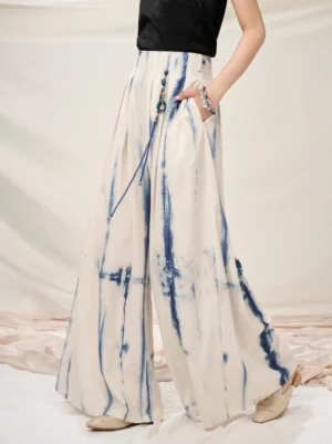 Back three-quarter view of modern Chinese-style wide-leg pants showing pleated high waist side pockets and decorative tassel pendant
