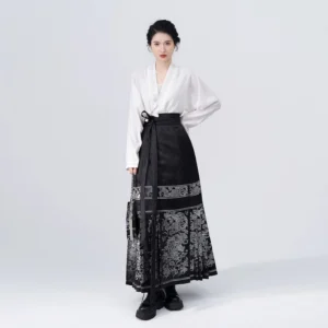 Modern daily Hanfu outfit with a white long sleeve cross-collar blouse, black patterned Mamian skirt, black loafers, and matching handbag