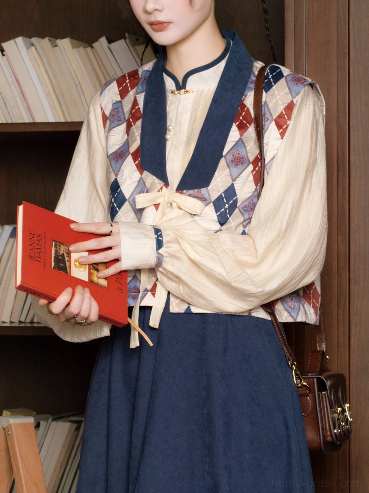 Close up of modern Hanfu upper layers showing the adjustable front tie argyle vest and structured stand collar long sleeve top