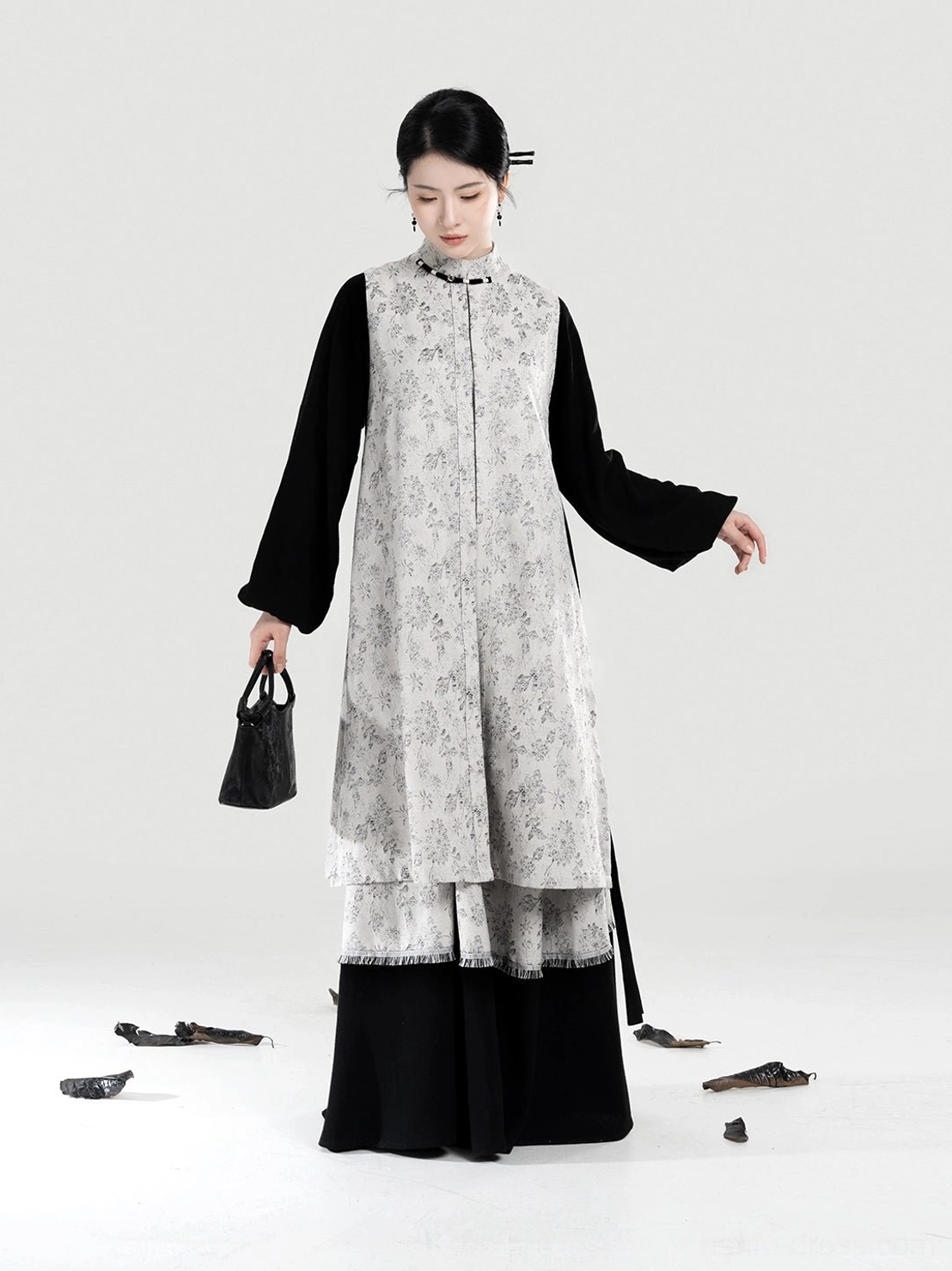 Three-quarter front view of modern Hanfu bijia vest outfit with black bow sleeve top layered skirt and black handbag