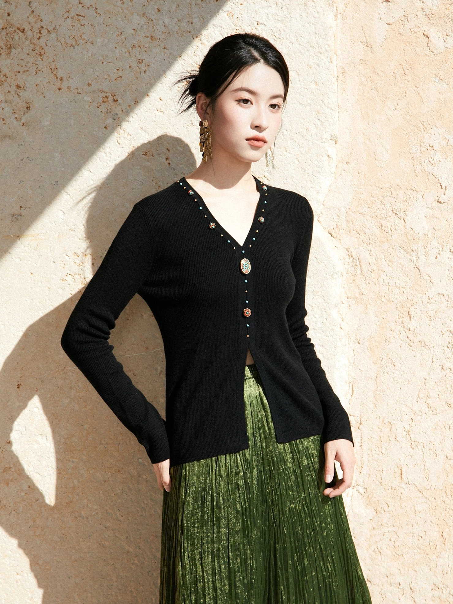Black modern Hanfu V-neck ribbed knit sweater cardigan with decorative bead and gem buttons paired with a green pleated skirt