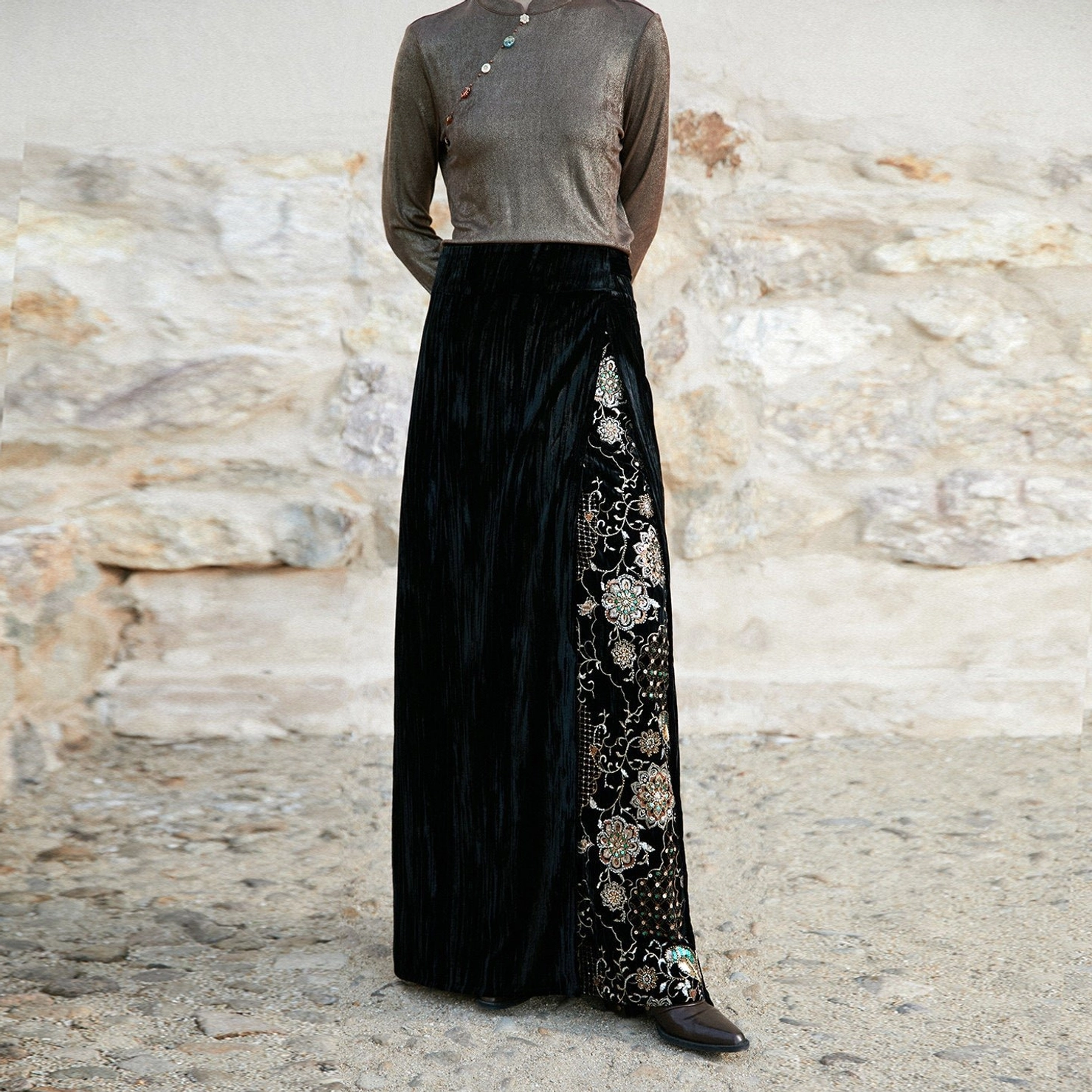 Back view of black long velvet wrap skirt with floral side embroidery paired with a taupe knit top in New Chinese Style fashion