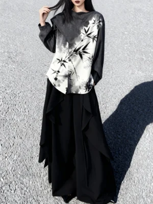 Full body side view of a woman wearing a modern Hanfu black and white bamboo ink print long sleeve top with loose lantern sleeves and a black ruffled maxi skirt