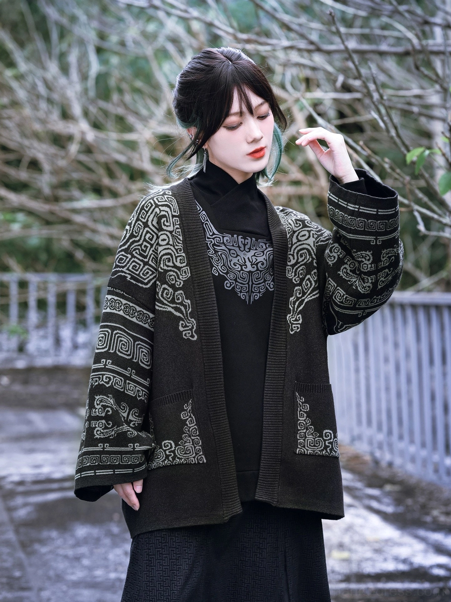 Outdoor modern Hanfu outfit featuring a black and gray Chinese bronze pattern knit cardigan layered over a black turtleneck and long black skirt