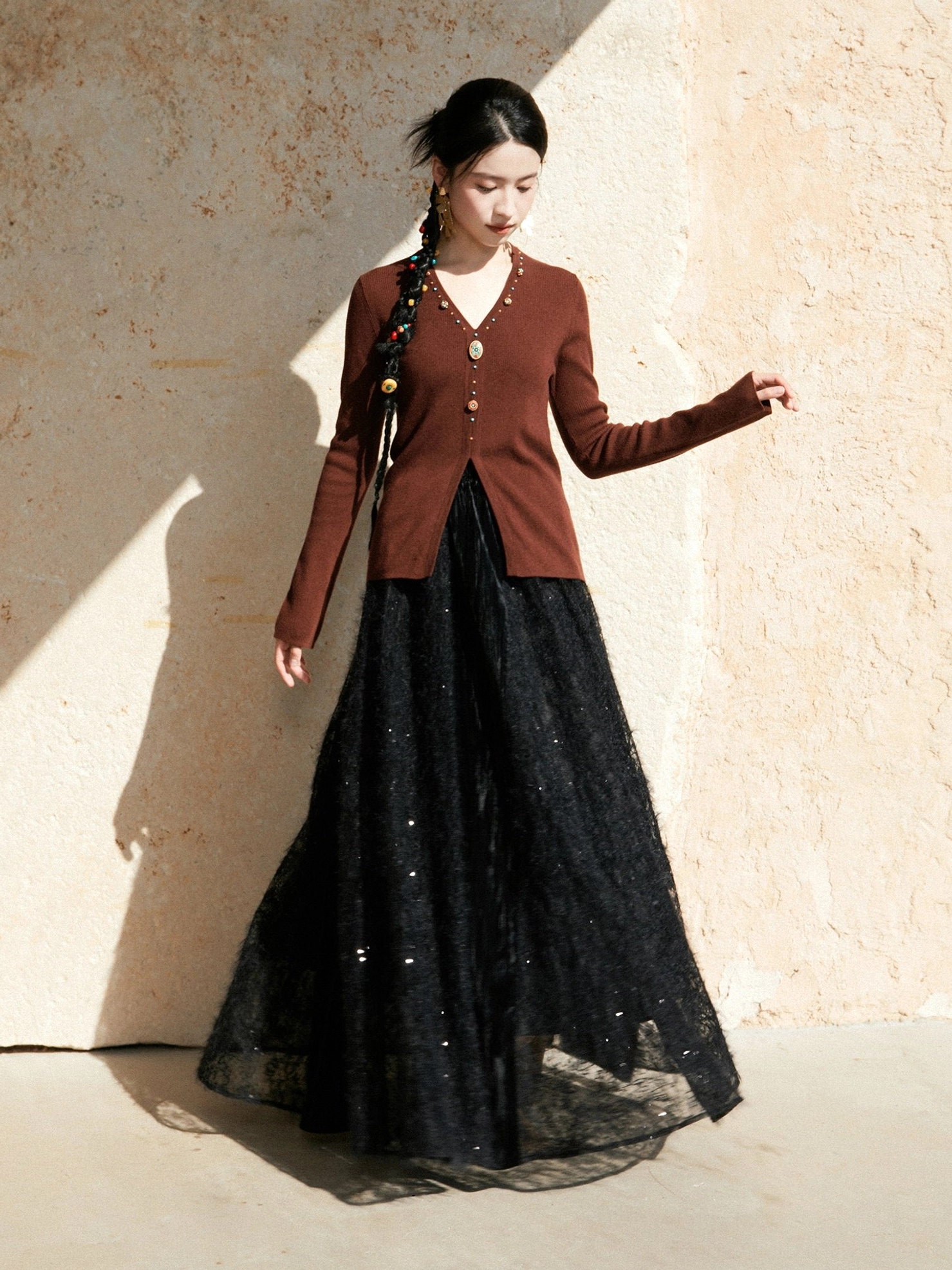 Brown modern Hanfu V-neck knitted cardigan sweater shown in a relaxed full-body look with a black glitter tulle long skirt