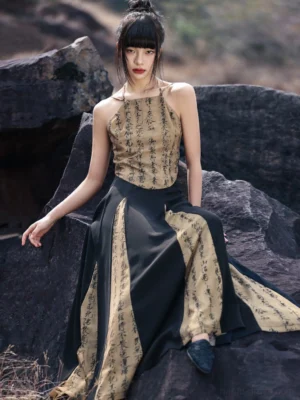 Modern Hanfu calligraphy print A-line maxi skirt styled with a matching halter camisole outdoors against dark rocks and dry grass