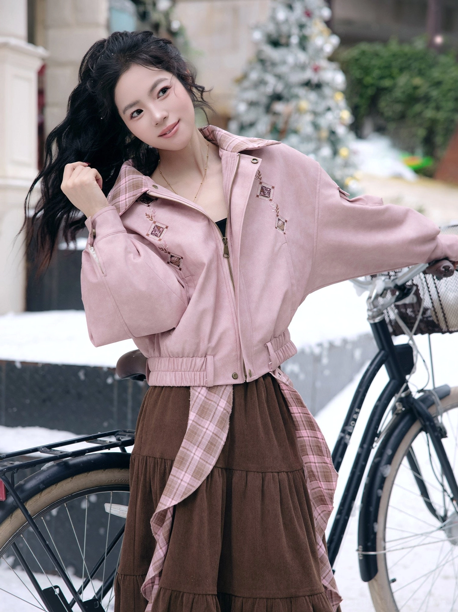 Modern Hanfu cinnamon-latte jacket and skirt outfit with star embroidery shown on a model beside a vintage bicycle in a snowy outdoor scene