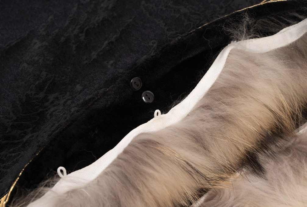 Close up flat lay of modern Hanfu coat interior showing white lining, black textured fabric, black buttons, and light brown removable fur trim