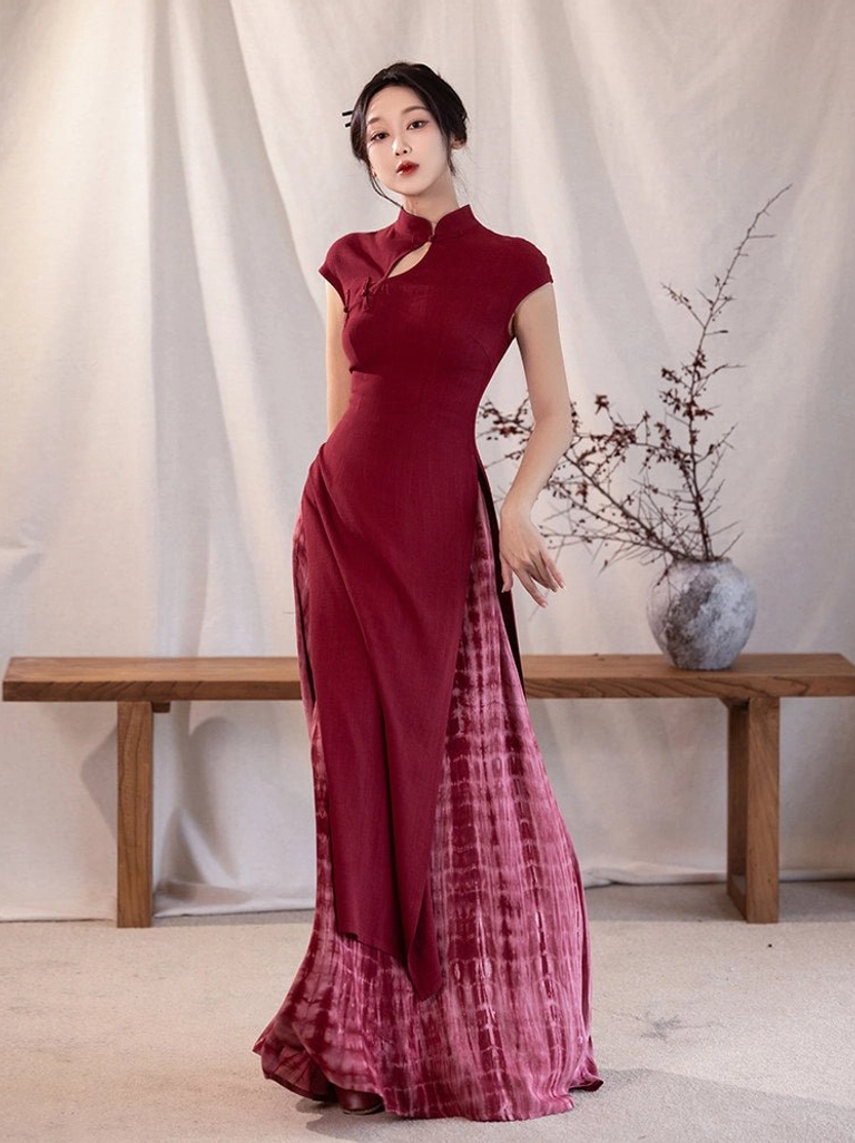 Modern Hanfu-inspired crimson Ao Dai two-piece dress with cap sleeves, stand collar cutout, fitted top, and pleated tie-dye maxi skirt