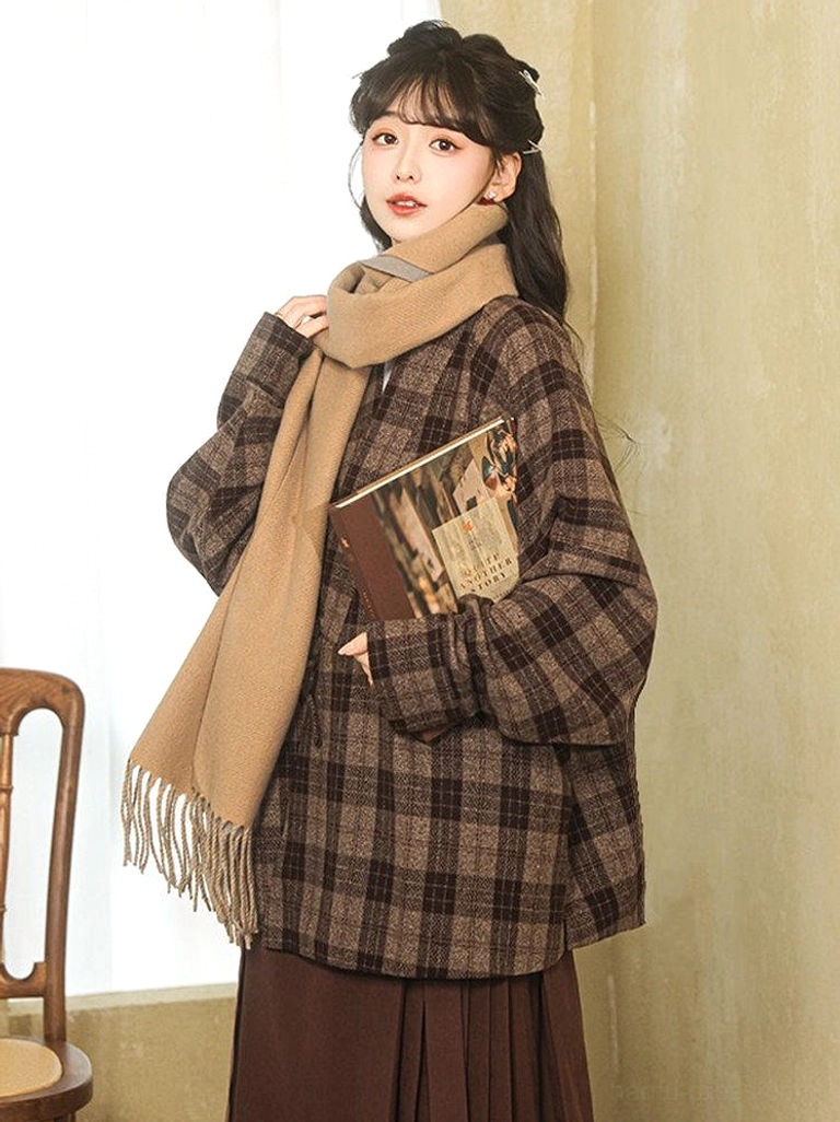 Modern Hanfu dark plaid cross-collar winter jacket close-up with relaxed wrap front and tan tassel scarf styling