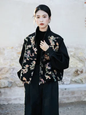 Front three quarter view of a modern Hanfu dragon sequin oversized cropped wool jacket with black base fabric, stand collar, front zipper, lantern sleeves, and adjustable drawcord hem