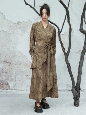 Full-body front view of a modern Hanfu dusty brown V-neck wrap maxi dress with vintage ink floral jacquard, long sleeves, tied waist sash, and asymmetric flowing hem