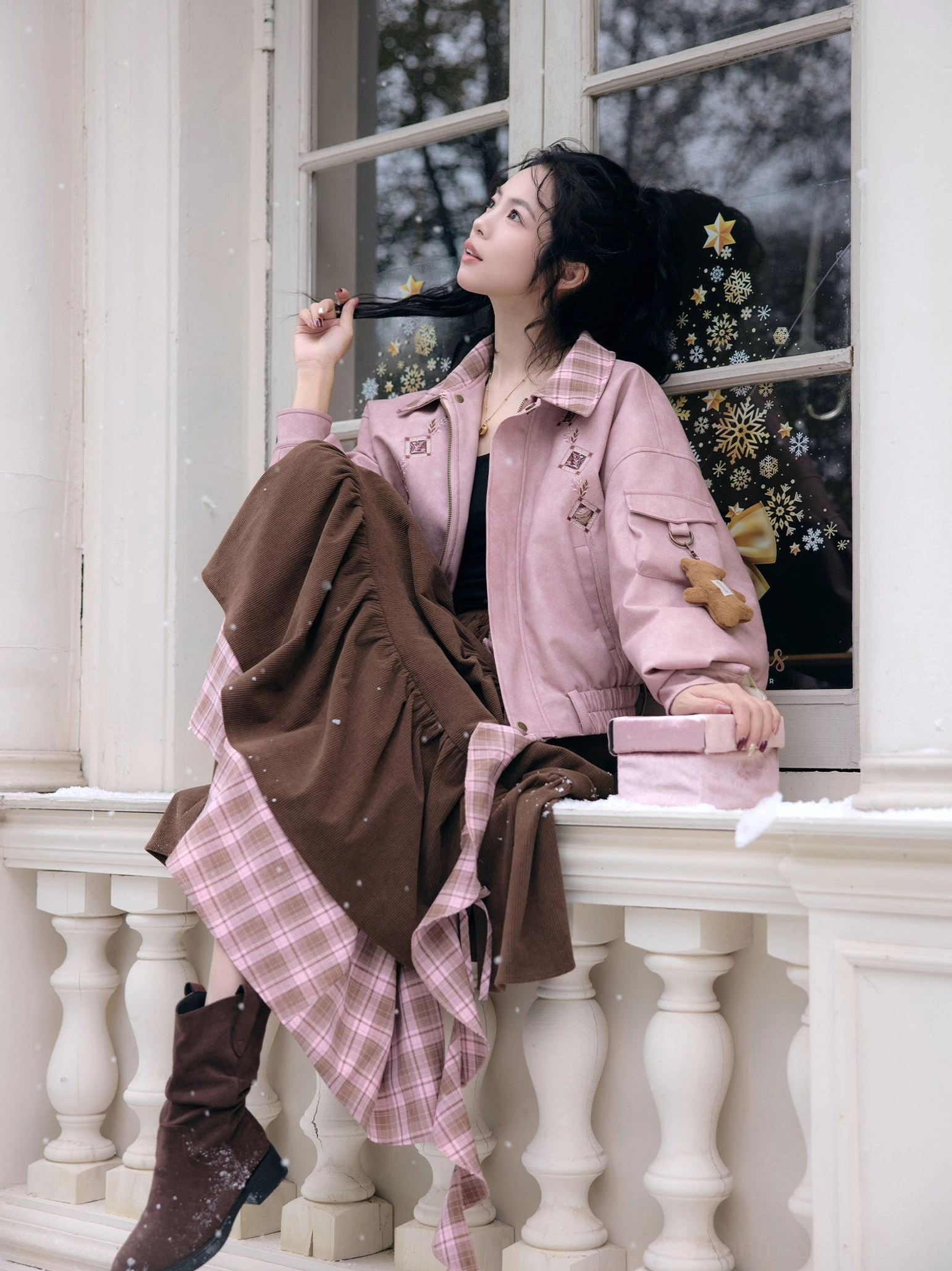 Dusty pink modern Hanfu cropped jacket and cinnamon brown tiered ruffle skirt set styled on a seated model at a vintage balcony with delicate embroidery and plaid layered trim