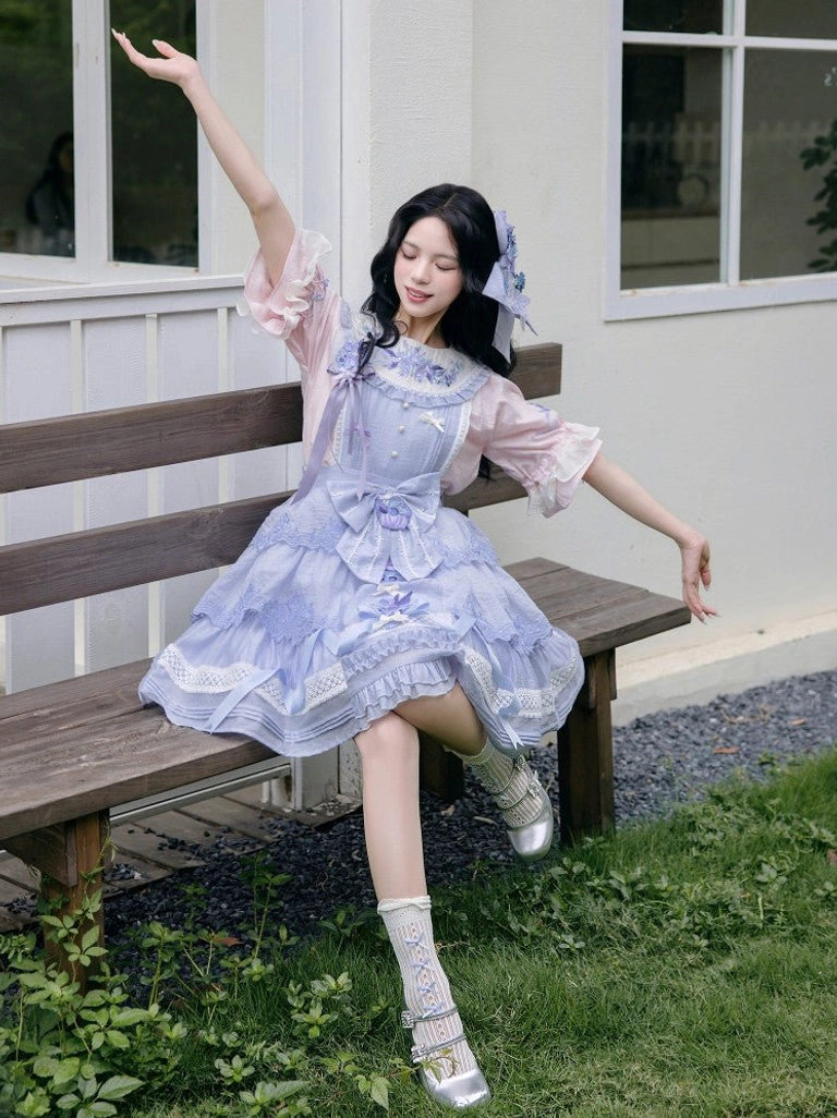 Three quarter view of a modern Hanfu fairy summer dress with tiered ruffle skirt matching hair bow frilled socks and silver shoes
