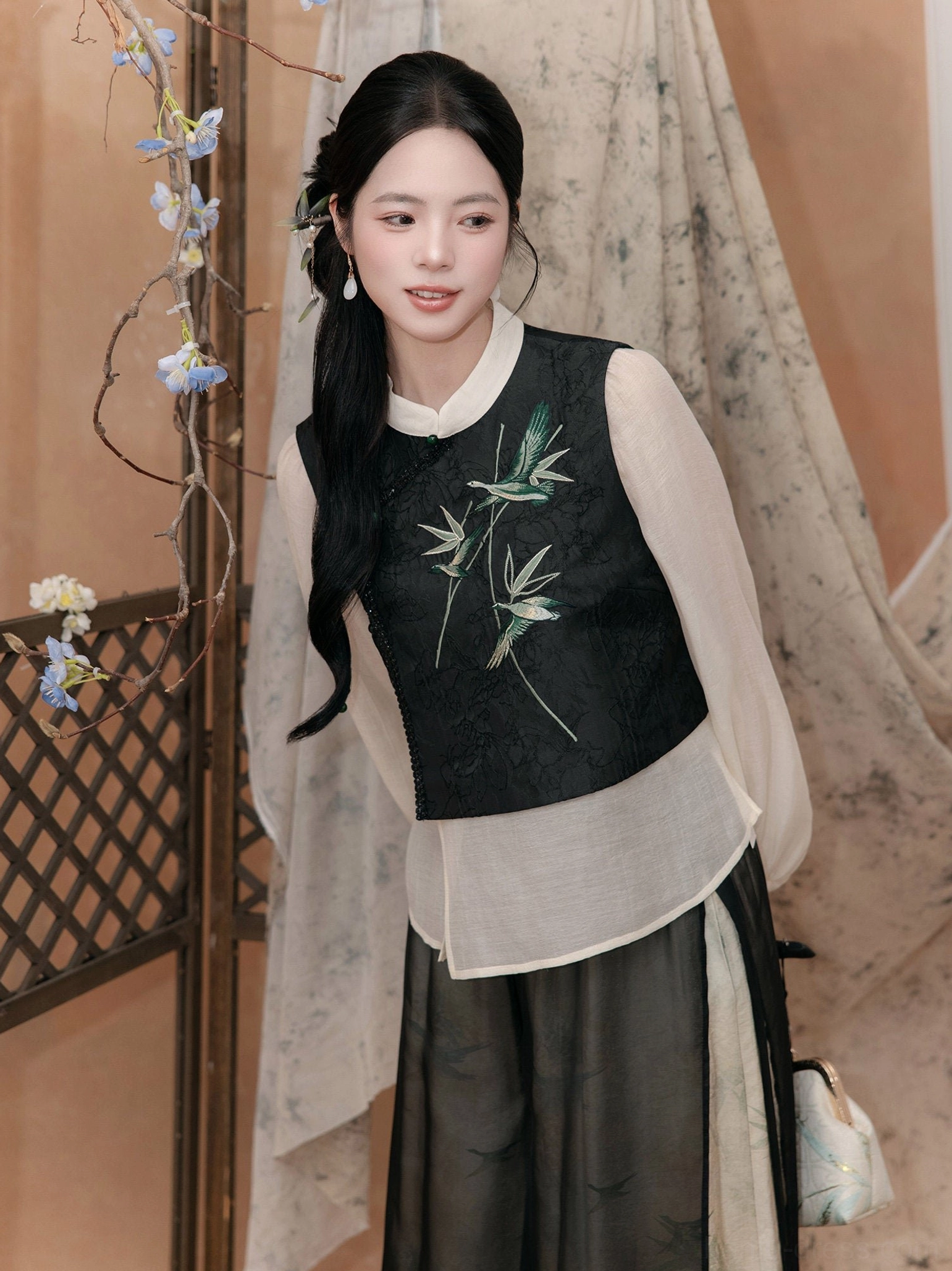 Detailed front view of a modern Hanfu faux-two-piece blouse with ivory lantern sleeves, dark embroidered vest panel, and bamboo leaf pattern