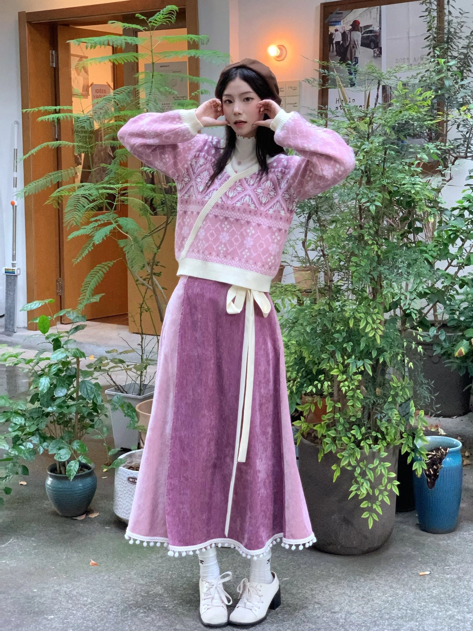 Front close-up view of a modern Hanfu floral knit sweater with cross-wrap design styled with white socks and loafers